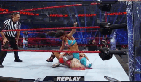 a woman is wrestling another woman in a wrestling ring with the word replay on the bottom