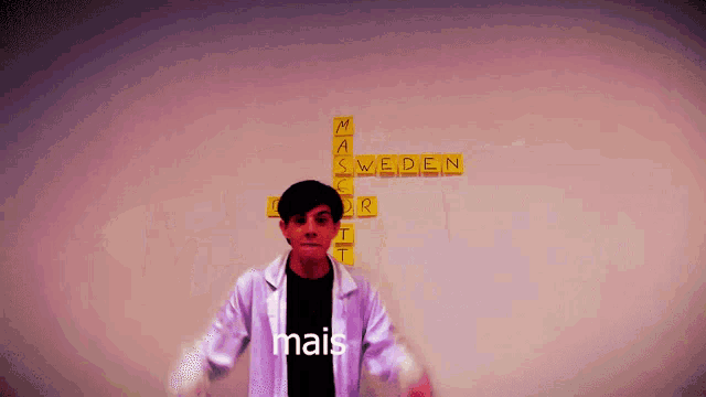 a man in a lab coat stands in front of a wall with scrabble tiles that say sweden