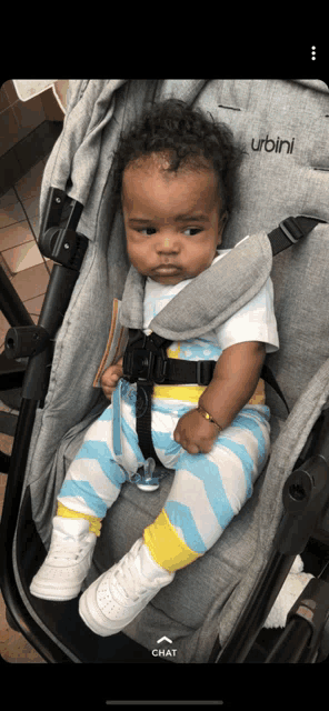 a baby is sitting in a stroller with the word urbini on it