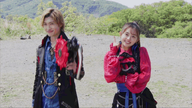a man and a woman standing next to each other holding weapons