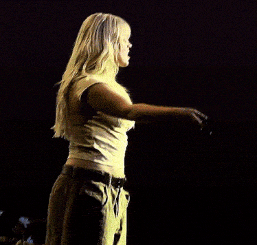 a blonde woman holding a microphone in her hand