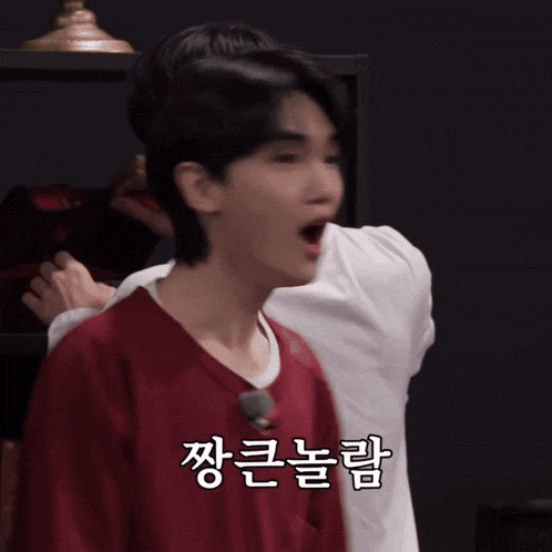 a man in a red shirt is being hugged by another man