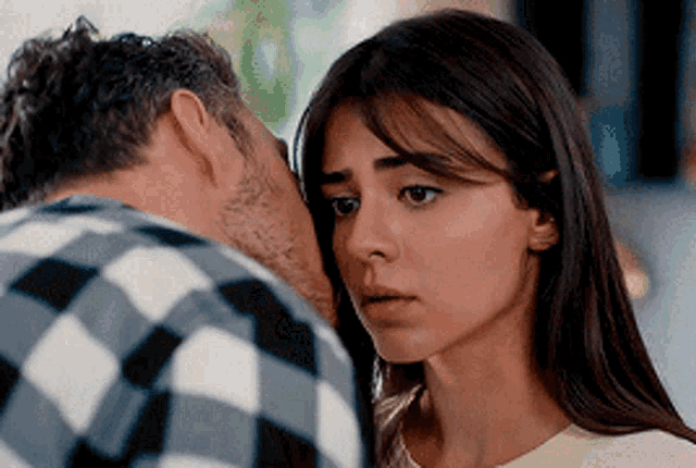 a man whispering into a woman 's ear