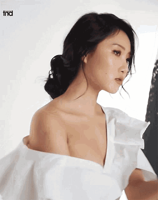 a woman in a white dress with the word tnd behind her