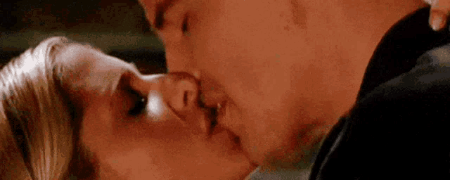 a man and a woman are kissing each other .