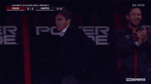 a man is standing in front of a powerade ad