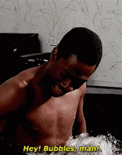 a shirtless man is taking a bath and saying hey bubbles man .