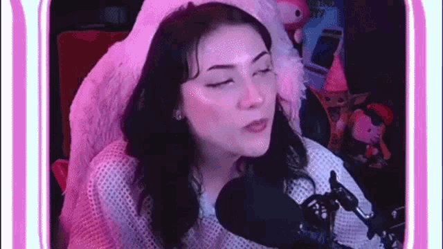 a woman is sitting in front of a microphone and making a face .
