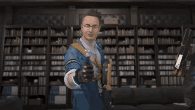 a man in a blue suit is standing in a library with a heart on his chest