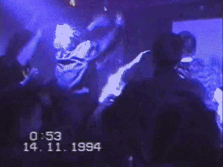 a group of people are dancing in a dark room with a date of 14 11 1994
