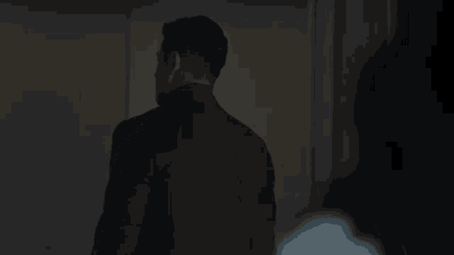 a man in a suit and tie is standing in the dark