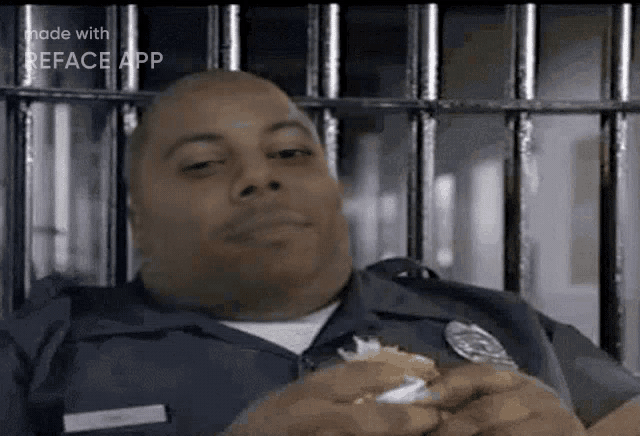a police officer is eating a hamburger in a prison cell .