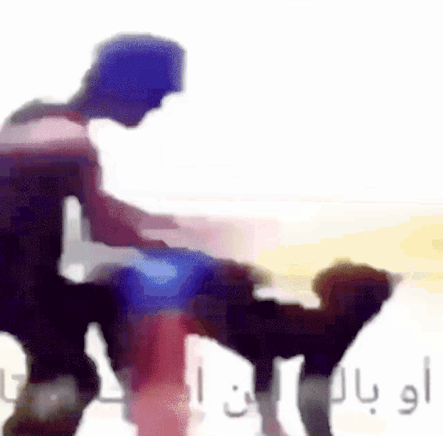 a blurry picture of a man and a dog with arabic writing .