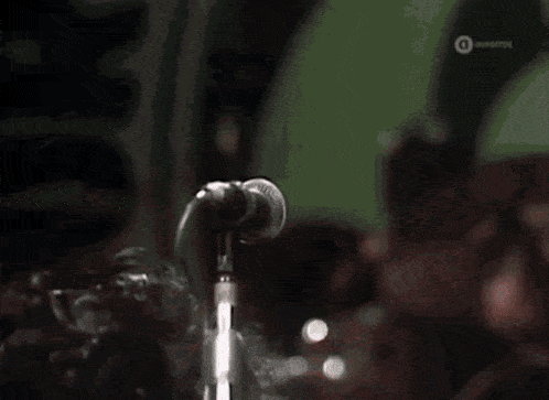 a man singing into a microphone with a watermark on the bottom right corner that says ' ovofros '