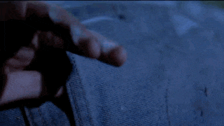 a person is holding a knife in their hand in a dark room