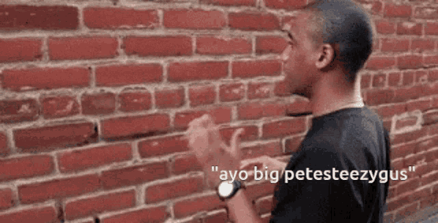 a man is standing in front of a brick wall with the words " ayo big petesteezygus " on the bottom