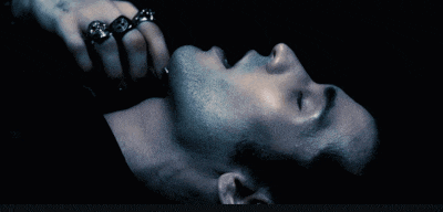 a man with rings on his fingers is laying down with his mouth open