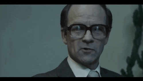 a man wearing glasses and a suit is talking and saying `` i 'll keep that in mind '' .
