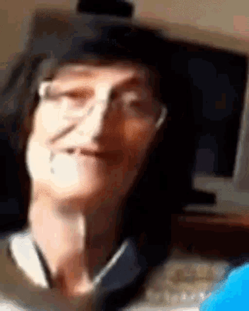 a close up of a woman wearing glasses making a funny face in a blurry photo .