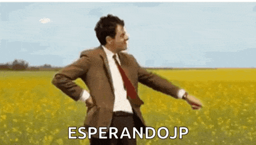a man in a suit and tie is dancing in a field of flowers .