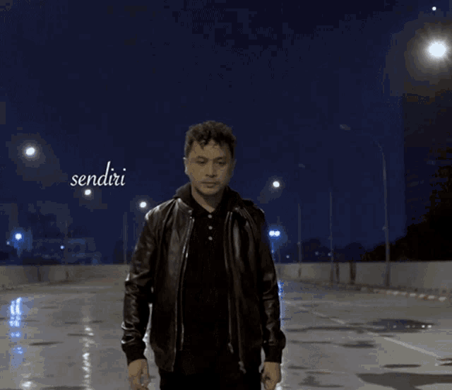 a man in a leather jacket is standing in front of a sign that says " sendiri "