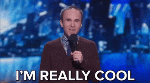 a man is standing on a stage holding a microphone and saying i 'm really cool .