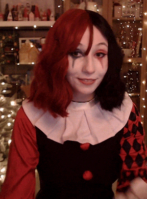 a woman wearing a harley quinn costume with red and black hair