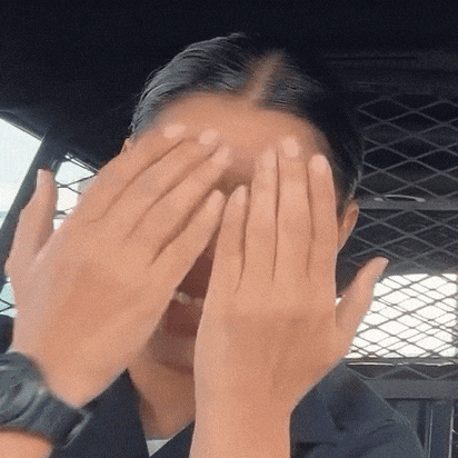 a woman is covering her face with her hands in a cell .