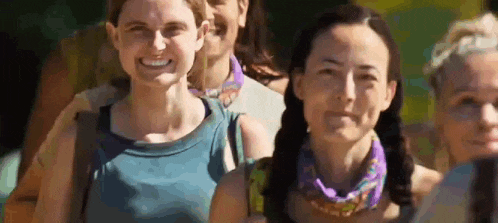 a group of women are standing in a line and smiling .