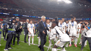 a man in a suit talks to a soccer player wearing number 17