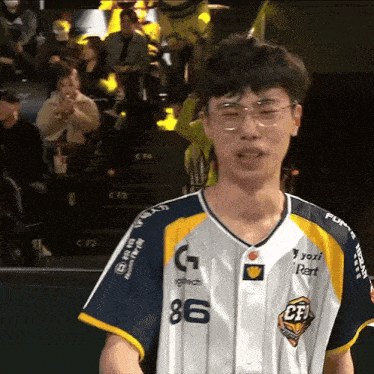 a man wearing glasses and a shirt that says 86