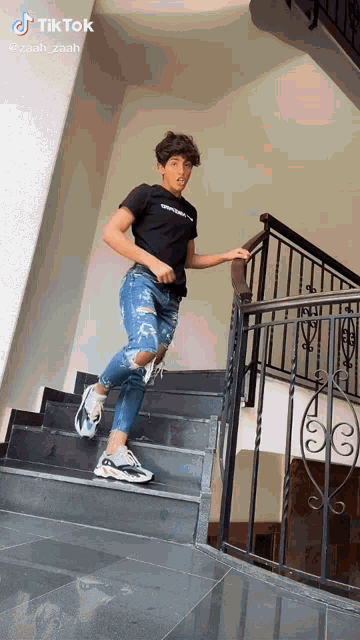 a young man is standing on a set of stairs with a tiktok watermark on the bottom