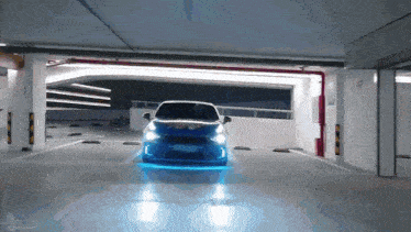 a car is driving through a parking garage with a blue light on it