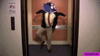 a man in a suit and tie is dancing in an elevator with a sign on the wall that says " a fire of fire "