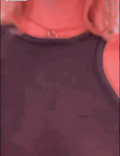 a woman in a black tank top is walking down a street