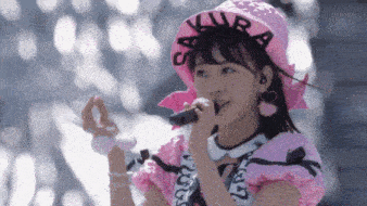 a girl in a pink hat is singing into a microphone
