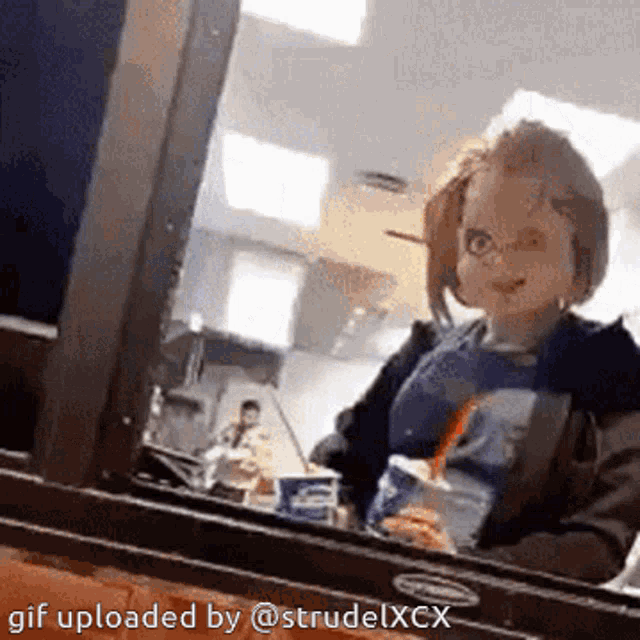 a gif uploaded by @strudelxcx shows a doll in a restaurant