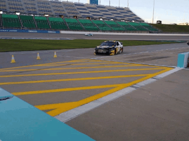 a mustang race car is parked on the side of a race track