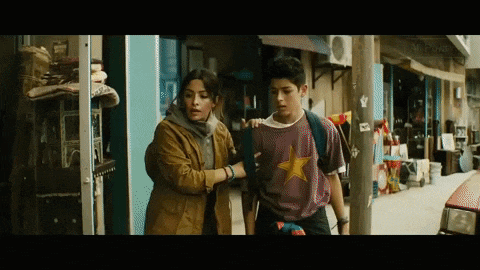 a boy wearing a shirt with a yellow star on it