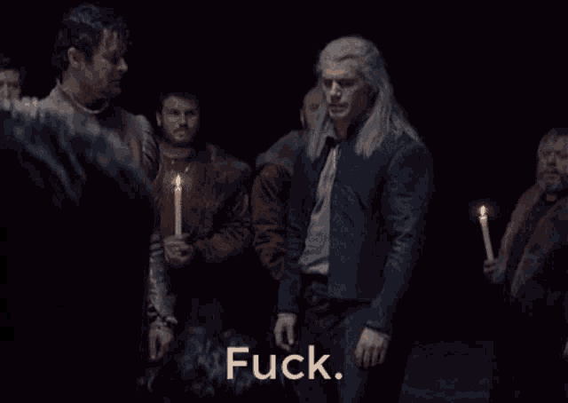 a group of men are holding candles and one of them is saying " fuck "