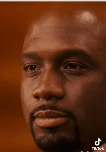 a close up of a man 's face with a tiktok logo on the bottom right