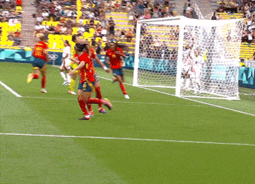 a group of soccer players on a field with one wearing a yellow jersey with the number 4 on it