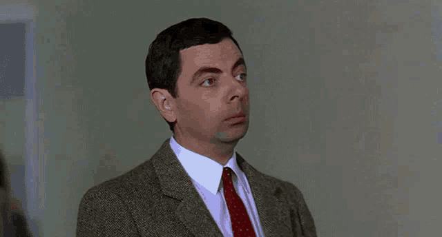 a man in a suit and tie is making a funny face .
