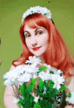 a woman with red hair is holding a bouquet of daisies
