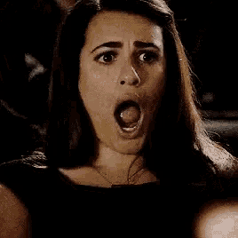 a woman is sitting in a theatre with her mouth open .