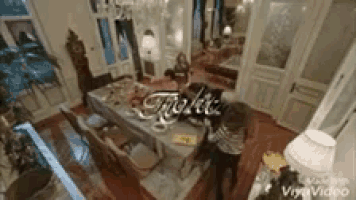 an aerial view of a dining room with a table and chairs and a chandelier .