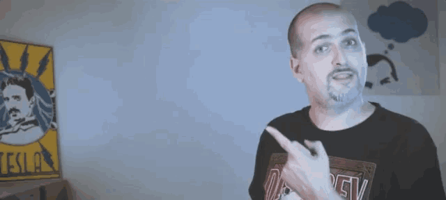 a man in a black shirt is pointing at something with the words that 's what she said behind him