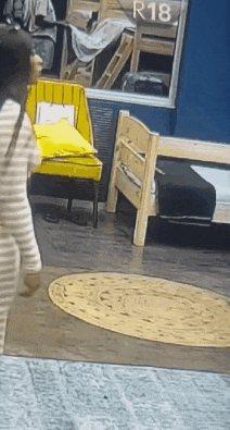 a woman is walking in a room with a sign that says r18 on it