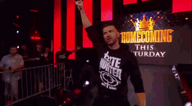 a man wearing a t-shirt that says taste water is walking on stage