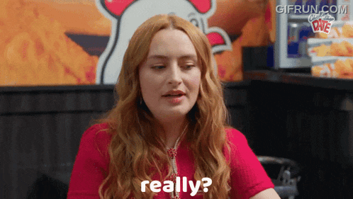 a woman in a red shirt says really in front of a chicken sign